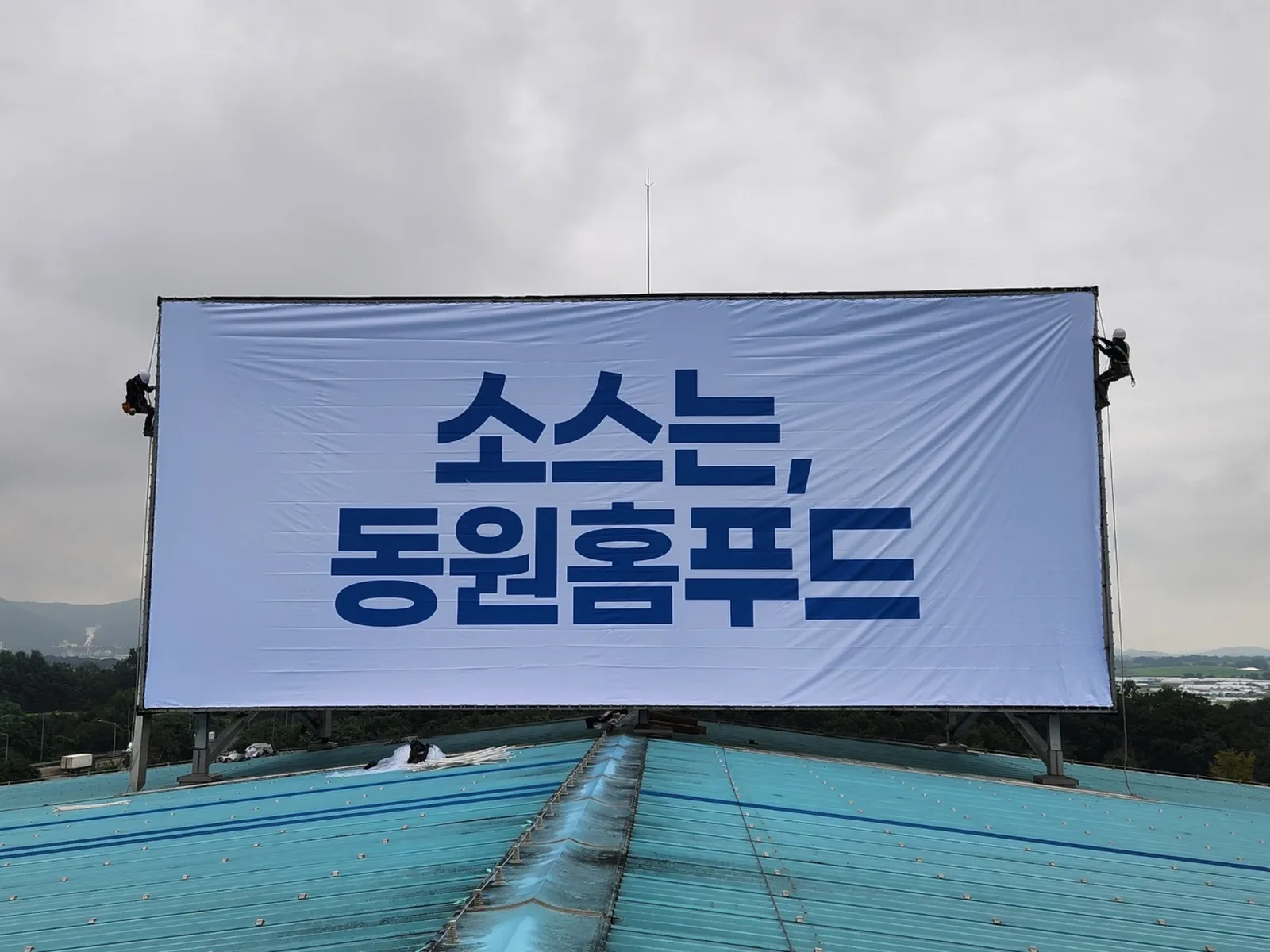옥상 대형 게시탑 구조물에 완성 설치된 대형 배접막(현수막) 정면 전경
